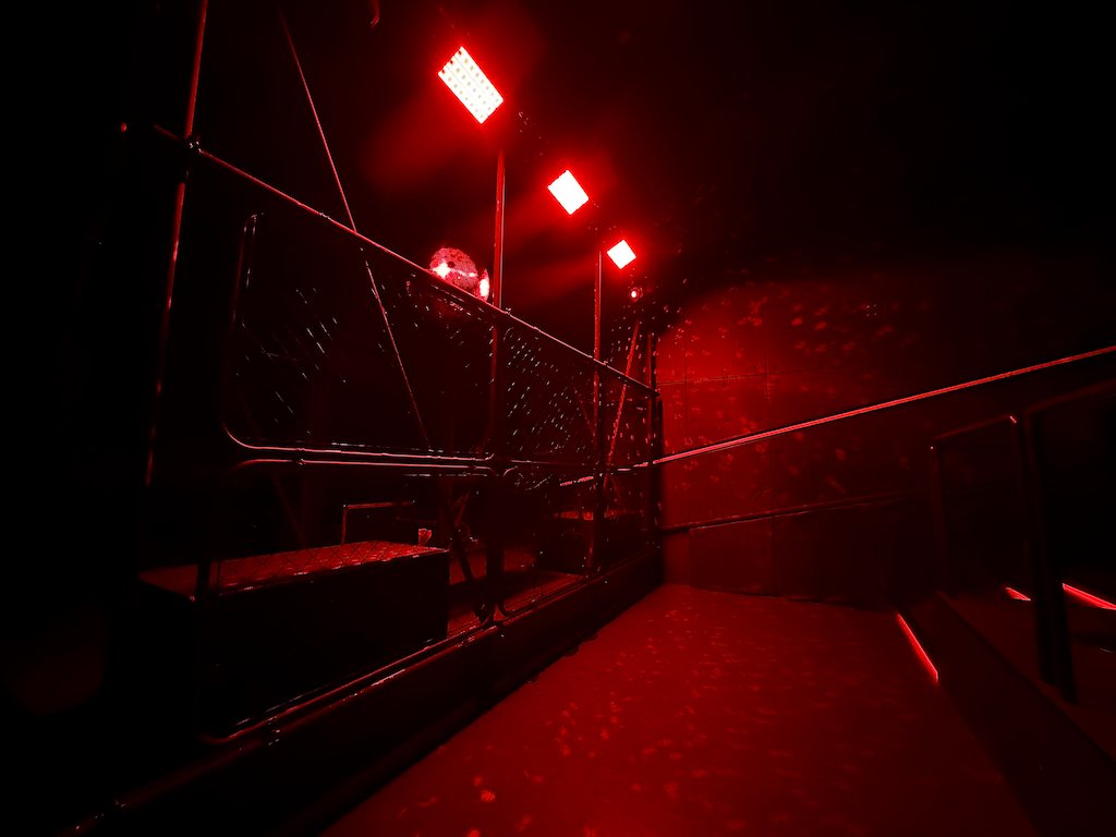 Along the wire-mesh enclosure in 3F SECRET CLUB, red light on the walls and floor