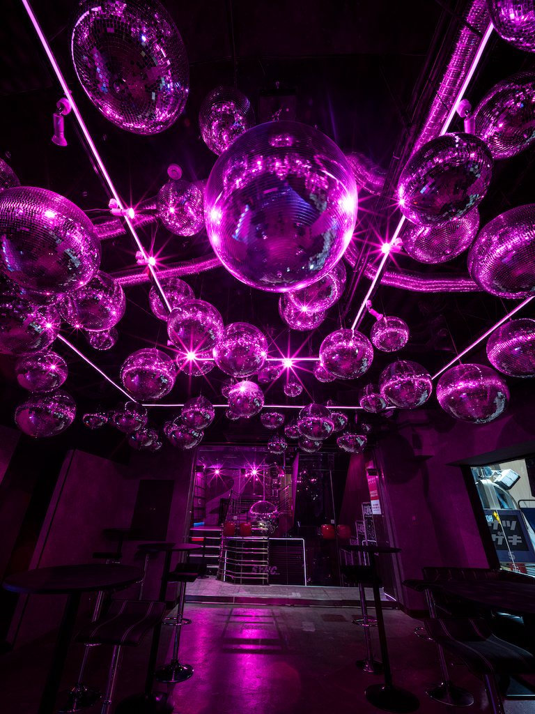 Countless mirror balls hanging from the bar ceiling above the tables