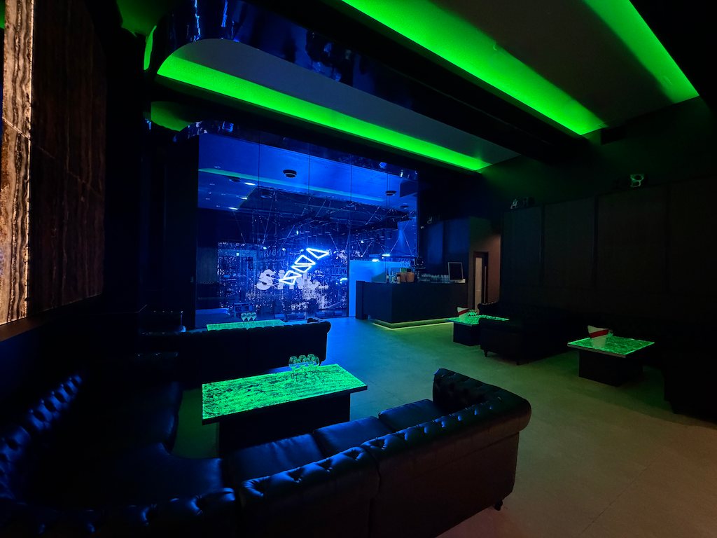 Leather sofa seating and an illuminated table in 3F VVIP ROOM, the main floor beyond the glass